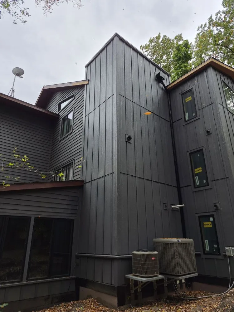 After: finished dark vertical board and batten siding