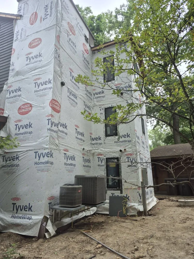 Before: tall home wrapped in housewrap
