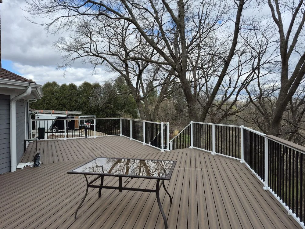 Second-story composite deck with white railings and black balusters